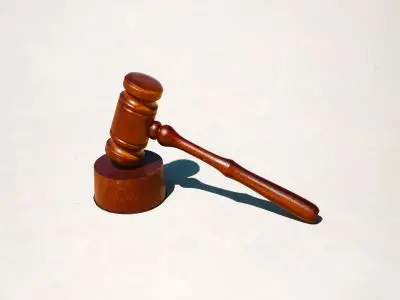 A wooden gavel resting face down on a flat surface.