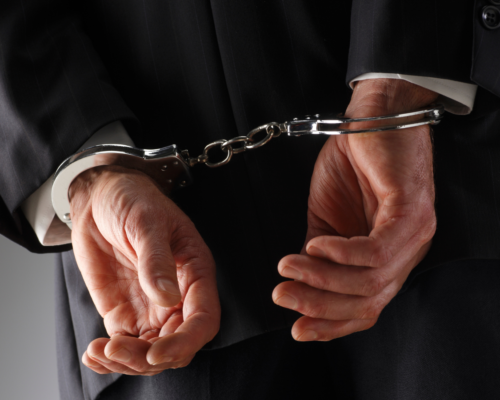 a man in handcuffs wearing a suit.