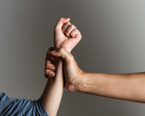 A womans fist held by a mans hand