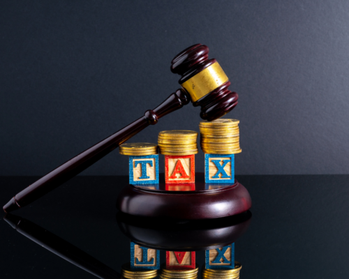 A judges gavel over letter cubes that spell TAX