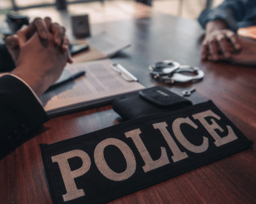 Midsection Of People Sitting On Table At Police Station