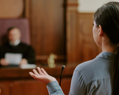 Woman testifying in a courtroom before a judge, illustrating the role of expert witnesses in challenging fire investigations and arson charges in Los Angeles.