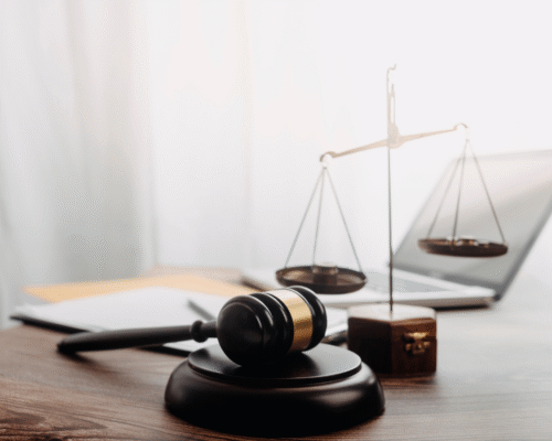 Close-up of a judge’s gavel and scales of justice on a desk beside a laptop, representing federal grand jury proceedings, immunity agreements, and criminal defense strategy in Los Angeles.