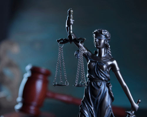 Statue of Lady Justice with balanced scales and a judge's gavel in the background, representing trade secret disputes, business litigation, intellectual property protection, and California trade secret law.