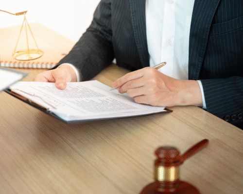 Attorney reviewing legal documents at a desk with scales of justice and a gavel, representing California debt collection disputes and potential extortion allegations.